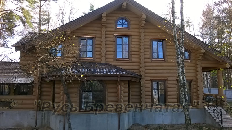 Фасад красивого рубленного дома из бревна с эркером