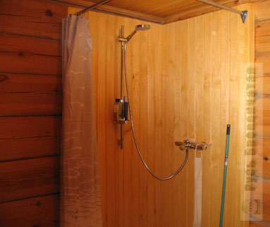 Рубленная баня из полуовального бревна с прозрачной дверцей печки